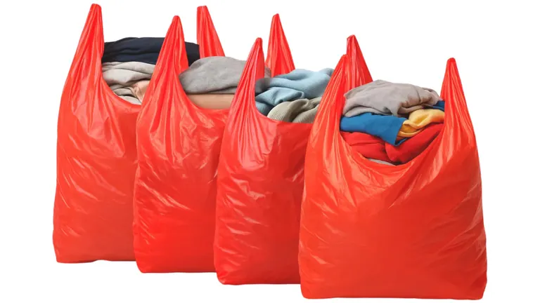 Four red plastic bags full of clothes